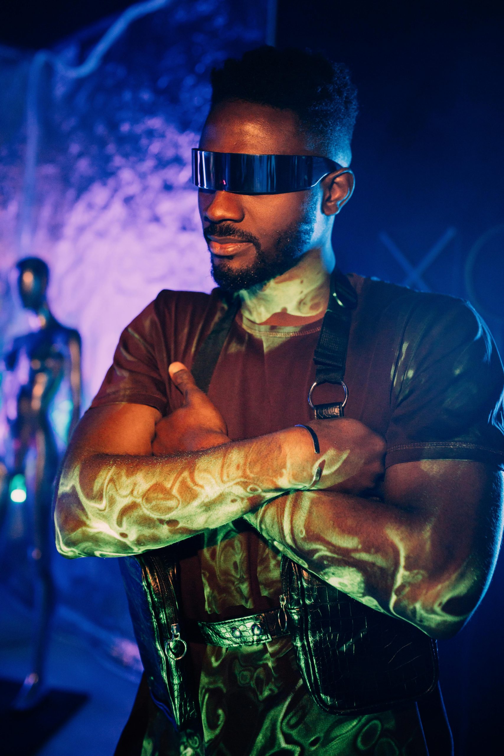 A confident man wearing a cyberpunk style with futuristic glasses in vibrant lighting.